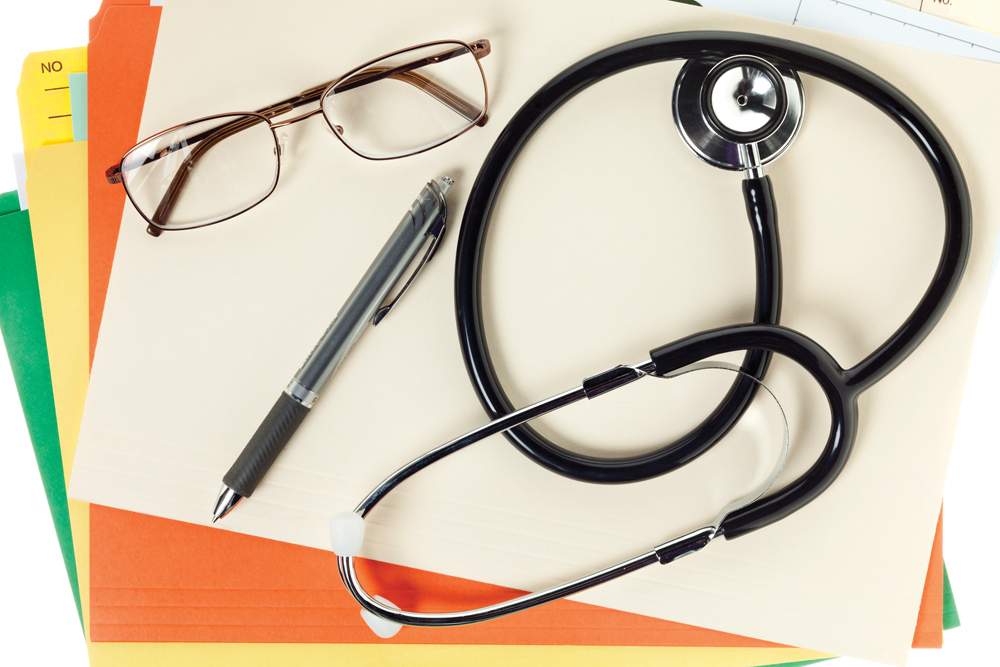 medical report with spectacles pen and stethoscope