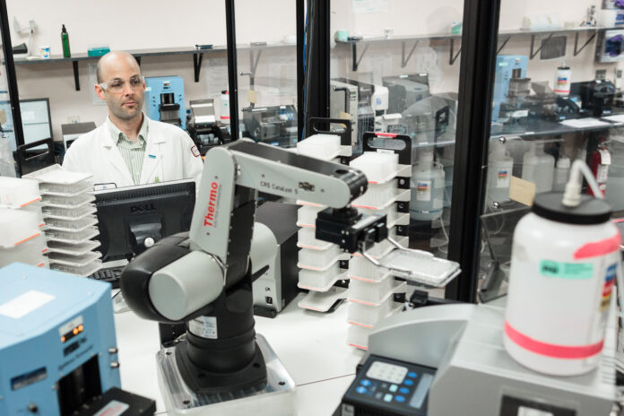 Production scientist Rob Halden operates a robotic microplate handling arm at Integrated DNA Technologies in Coralville Wednesday, August 8, 2012.