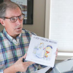 Steve Erickson shows off his new children’s book, “A Very Chilling Mystery.”