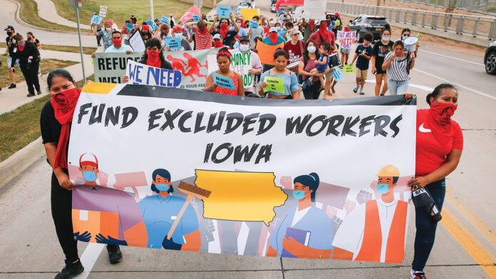 IC ARP FUNDING More than 100 excluded workers with Escucha Mi Voz marched through Iowa City demanding $1,400 checks.