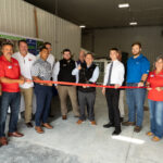 1-800-HANSONS employees and Cedar Rapids Metro Economic Alliance representatives participate in a ribbon cutting for the new Cedar Rapids location of the company on Aug. 19, 2022. CREDIT 1-800-HANSONS