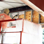 A Kinzler Construction Services employee-owner installs spray foam insulation at a commercial new-construction project. Spray foam can be used to fill gaps and stop air leaks in many areas of both new and existing homes or buildings.