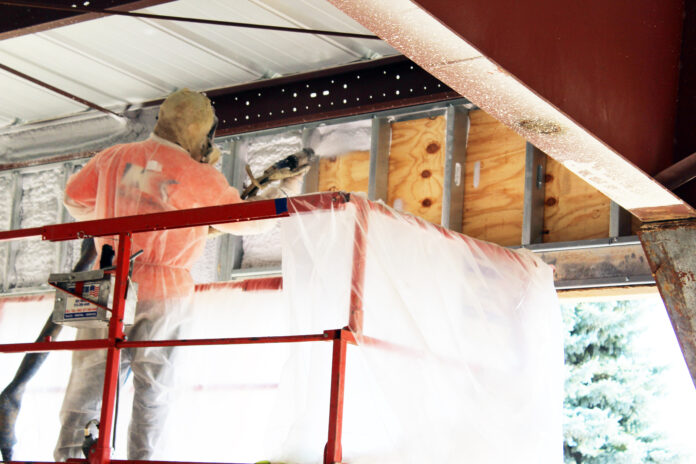 A Kinzler Construction Services employee-owner installs spray foam insulation at a commercial new-construction project. Spray foam can be used to fill gaps and stop air leaks in many areas of both new and existing homes or buildings.