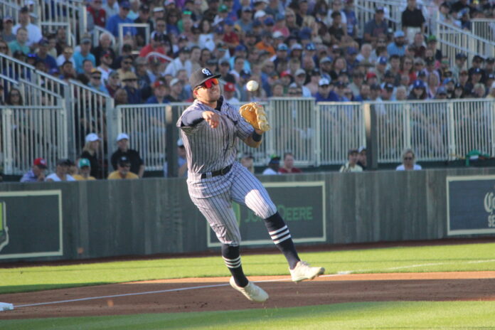 Cedar Rapids third baseman Seth Gray makes a running throw during the first minor league game played at the 
