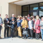 CRST employees smiles at a ribbon cutting event for its new Birmingham, Alabama facility. CREDIT CRST
