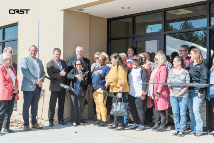 CRST employees smiles at a ribbon cutting event for its new Birmingham, Alabama facility. CREDIT CRST