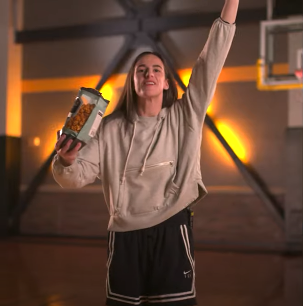 Caitlin Clark holds a bag of Almost Famous Popcorn during an advertisement supporting modernizing the Small Business Administration. CREDIT GOLDMAN SACHS YOUTUBE