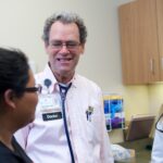 Family medicine physician, David Bedell, MD, attends to patient with a medical student. CREDIT UI HEALTH CARE