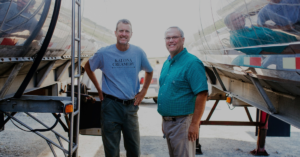Phil Forbes, small farm program director for Open Gates, and Bill Evans, CEO and owner, stand near milk tankers that transport milk from small family farms throughout Iowa and the Midwest for Open Gates' milk brokering business, Kalona Farms. CREDIT OPEN GATES GROUP