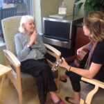 Music therapist Meghan Ross interacts with a resident during a one-on-one music therapy session at Oaknoll Retirement Residence.