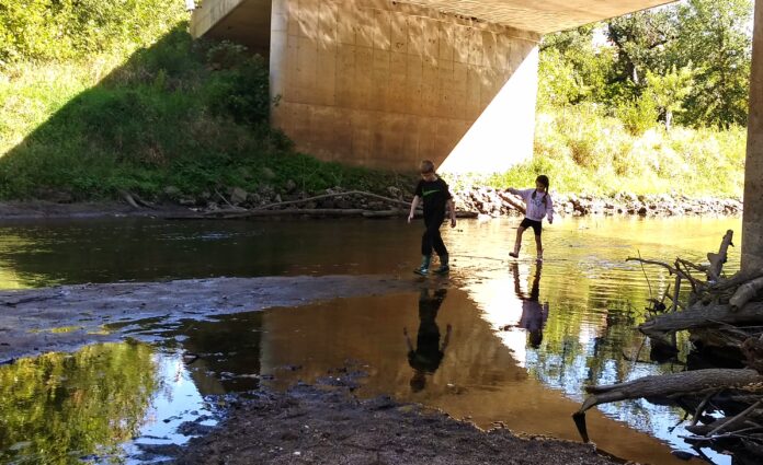 Students taking part in Indian Creek Nature Center's Fresh Air Academy play in water on the center's land. CREDIT INDIAN CREEK NATURE CENTER