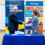 St. Ambrose University President, Amy C. Novak, EdD, and Mount Mercy University President, Dr. Todd A. Olson, sign the nursing articulation agreement between both institutions.