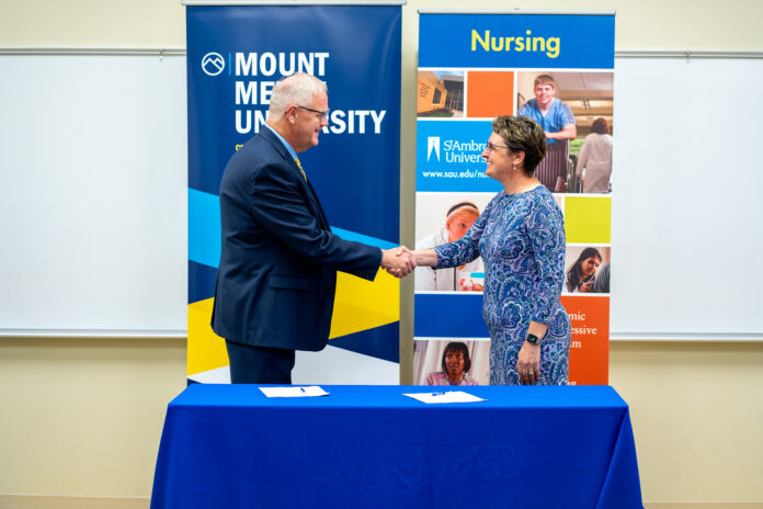 St. Ambrose University President, Amy C. Novak, EdD, and Mount Mercy University President, Dr. Todd A. Olson, sign the nursing articulation agreement between both institutions.