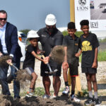 Members of the North Liberty community toss shovelfulls of dirt at the Solomon's Landing entertainment center groudnbreaking ceremony.