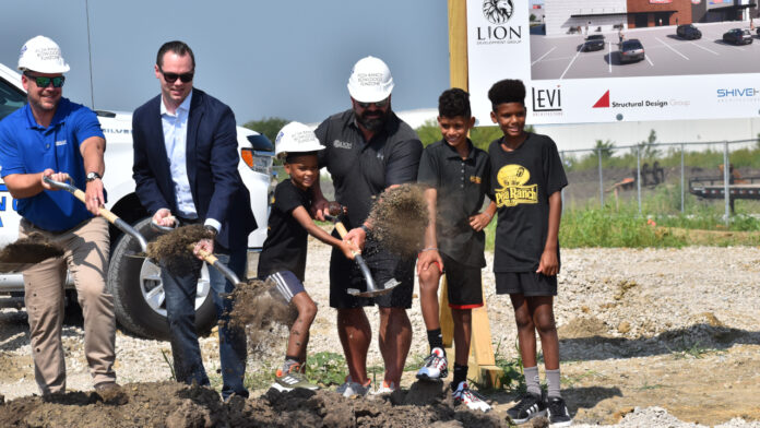 Members of the North Liberty community toss shovelfulls of dirt at the Solomon's Landing entertainment center groudnbreaking ceremony.