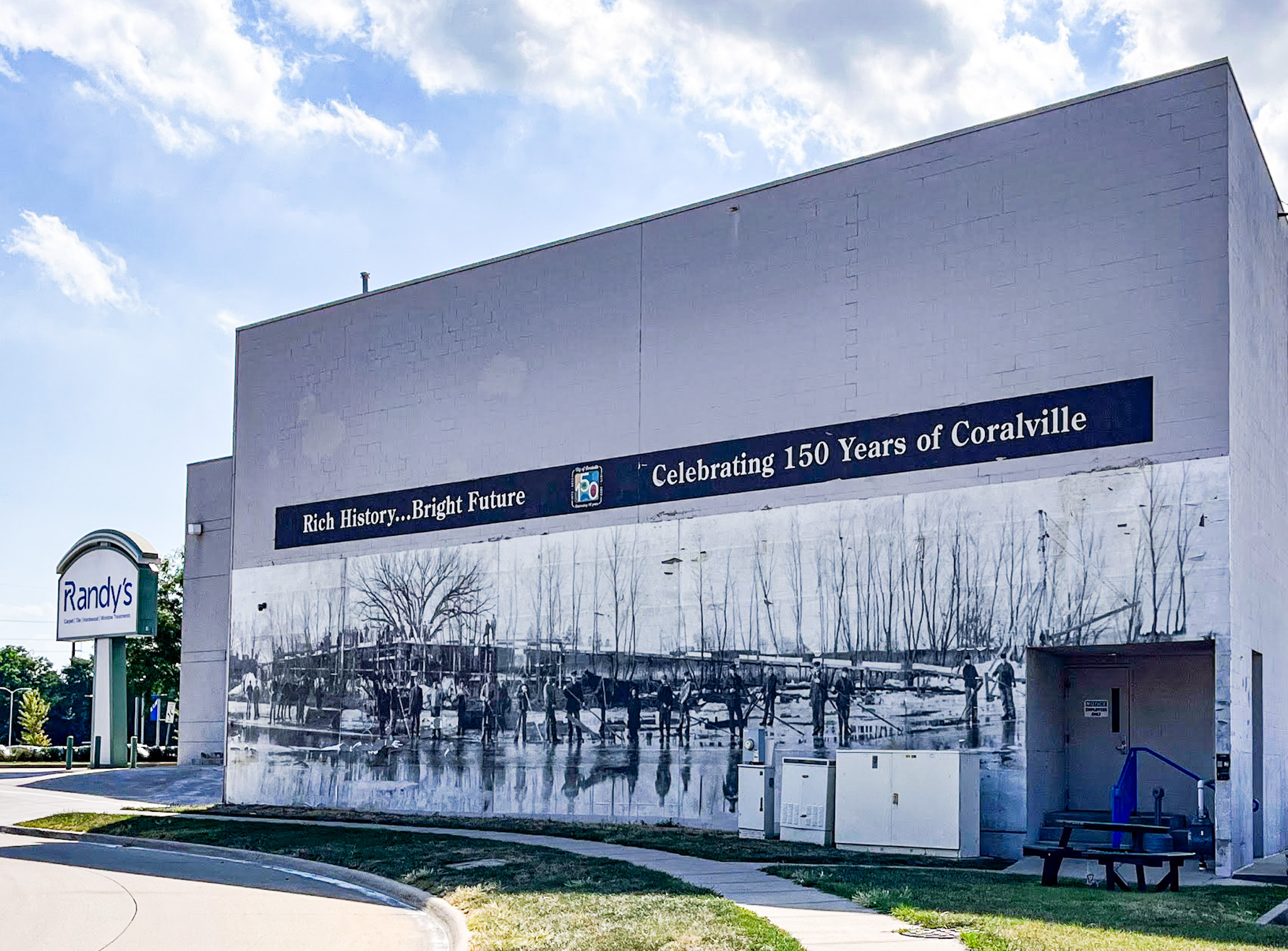 A mural commemorating the 150th anniversary of Coralville is seen on the side of Randy’s Flooring at 401 Second St. on July 26. CREDIT ELEANOR HILDEBRANDT