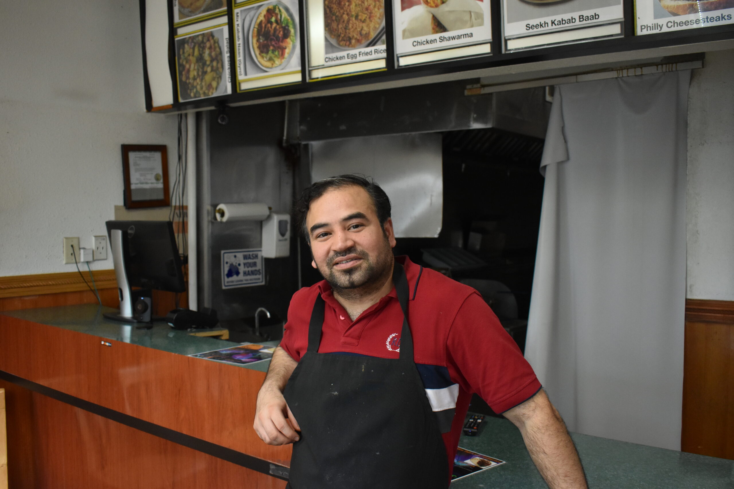Fawad Nawaz, owner of Hot & Roll, stands at his counter. Hot & Roll is the only Pakistani restaurant in Iowa City. CREDIT ANNIE BARKALOW