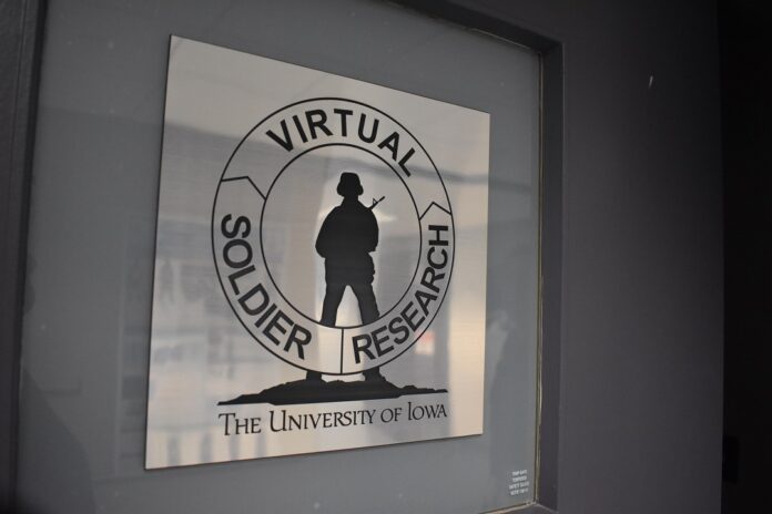 A metallic sign on a door has a silhouette of a soldier holding a gun. A circle goes around the soldier with the words 