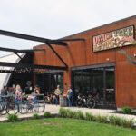 The Des Moines' Peace Tree taproom is a red brick building. Parked outside are bicycles.