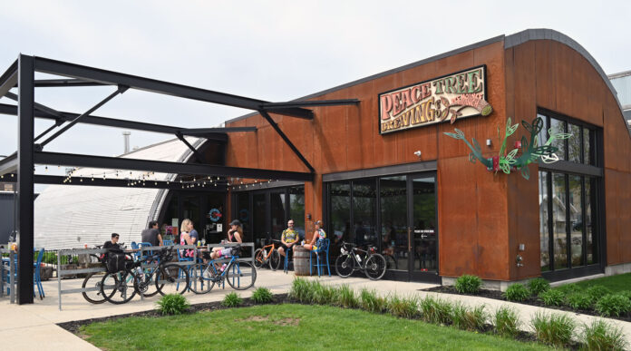 The Des Moines' Peace Tree taproom is a red brick building. Parked outside are bicycles.