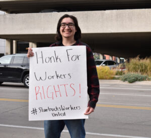 Luis Aispuro, Starbucks barista, holds a sign demanding workers' rights.