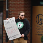 A protester stands outside the downtown Iowa City Starbucks at 228 S. Clinton St.