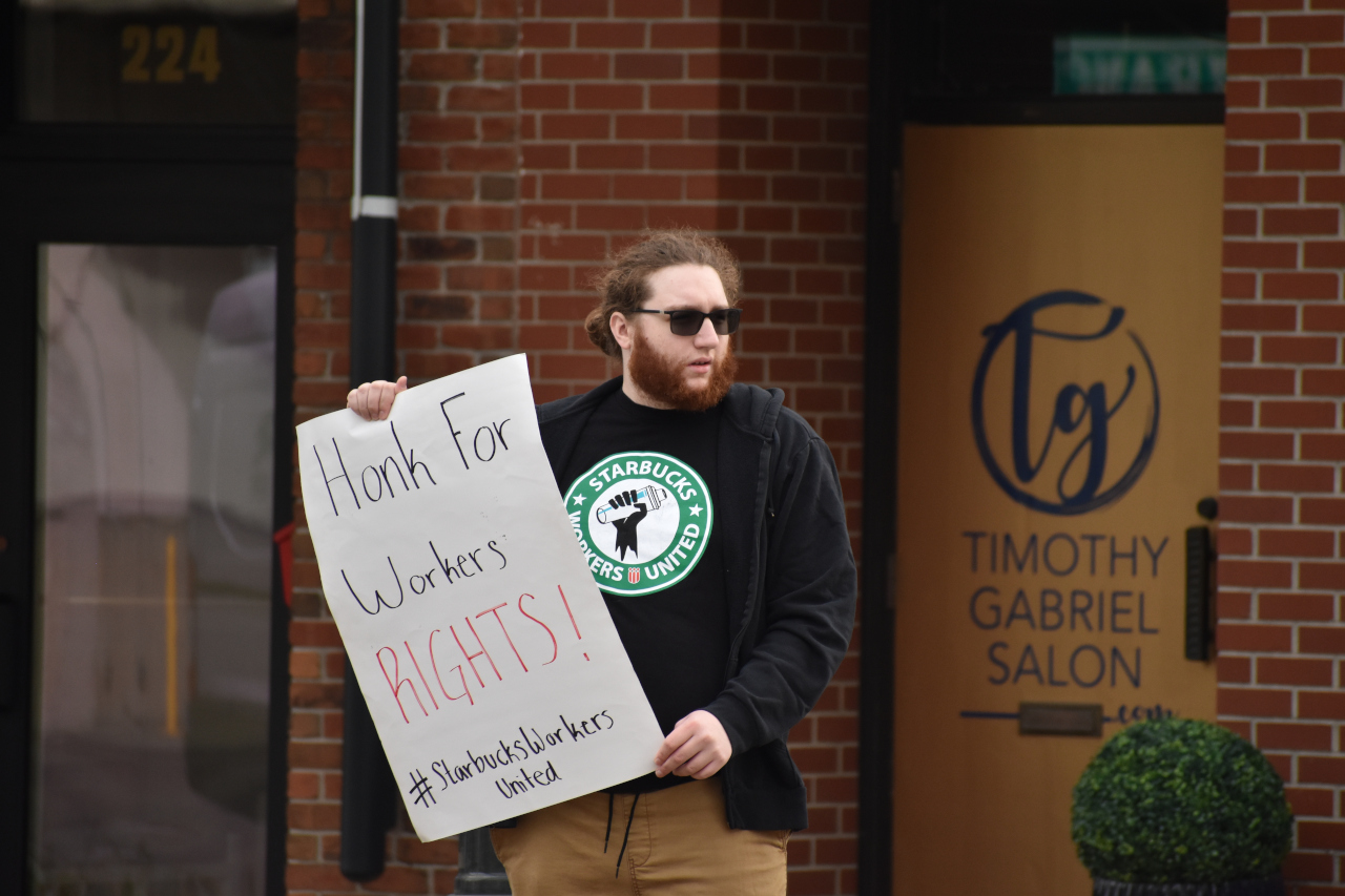 A protester stands outside the downtown Iowa City Starbucks at 228 S. Clinton St.