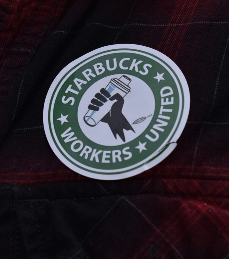 A barista dons a Starbucks Workers United sticker.