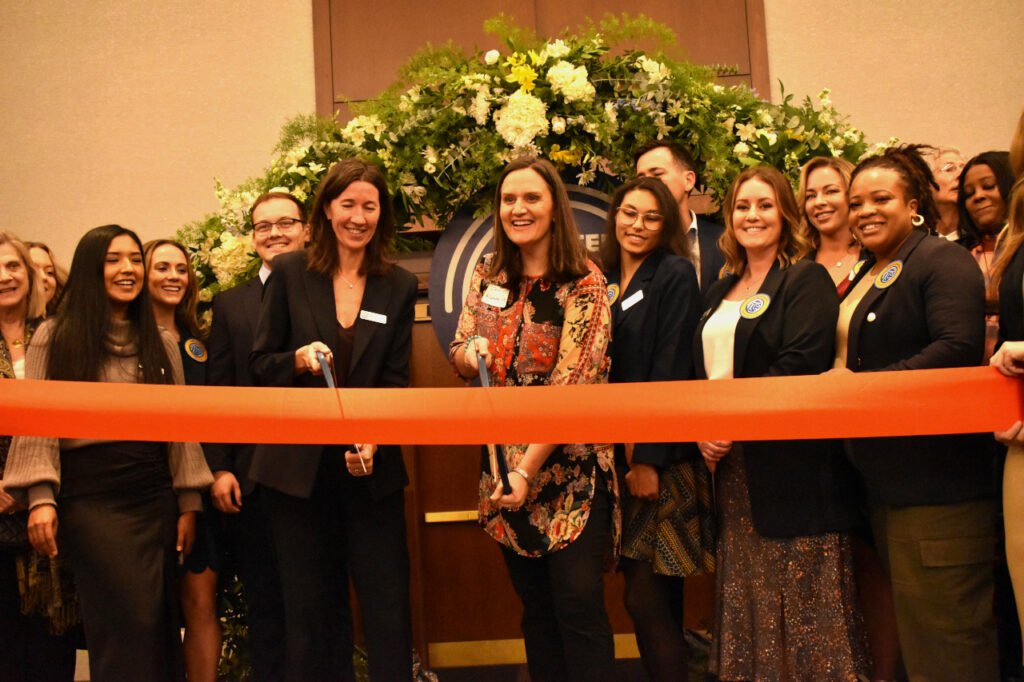 Nancy Bird (L) and Jennie Wunderlich (R) are poised to cut the ribbon celebrating the official launch of Greater Iowa City, Inc.
