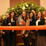 Nancy Bird (L) and Jennie Wunderlich (R) are poised to cut the ribbon celebrating the official launch of Greater Iowa City, Inc.