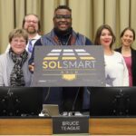 Members of the Iowa City Council display the Gold Level designation plaque from SolSmart.