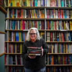 Suzanne Gleeson of Prairie Lights Books poses with some of author James Patterson's books. Ms. Gleeson was one of six Iowan recipients of Mr. Patterson's Holiday Bookstore Bonus Program.