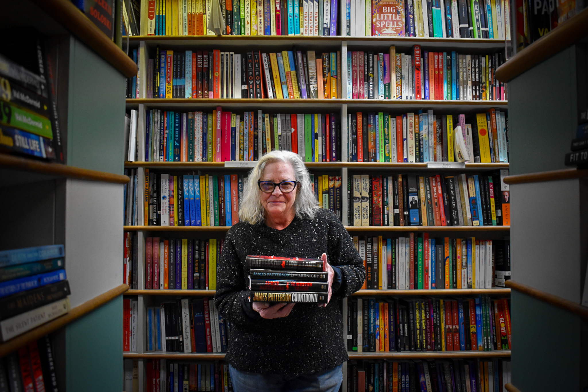 Suzanne Gleeson of Prairie Lights Books poses with some of author James Patterson's books. Ms. Gleeson was one of six Iowan recipients of Mr. Patterson's Holiday Bookstore Bonus Program.