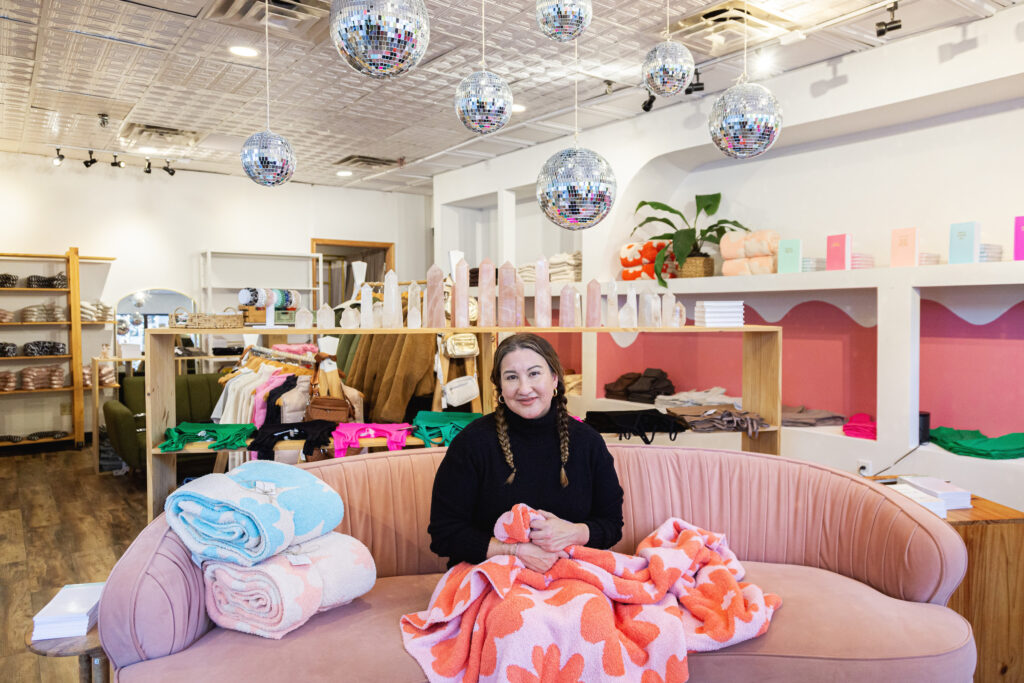 Monica Berry sits on a couch at Cielo Goods.