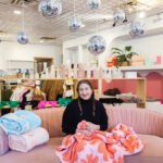 Monica Berry sits on a couch at Cielo Goods.