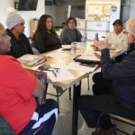 Business owners from the South of 6 Business District in Iowa City sit in on a mini-Venture school session Jan. 8.