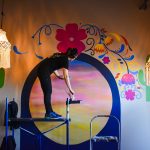 Candice Warby paints a mural at Rio Burritos in Cedar Rapids. Ms. Warby founded her art business, Whimsical Twist, in 2018. CREDIT ALEXANDRA OLSEN