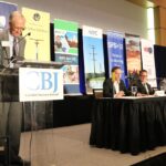 Jack Evans, Chair of the Board of the Hall-Perrine Foundation, moderates a panel of Corridor business leaders at the CBJ's 2024 Economic Forecast Luncheon.