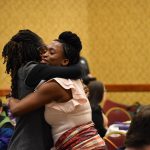 Two women embrace at the Catherine McAuley Center Immigration & Business Luncheon Awards, at the Radisson Hotel Cedar Rapids.