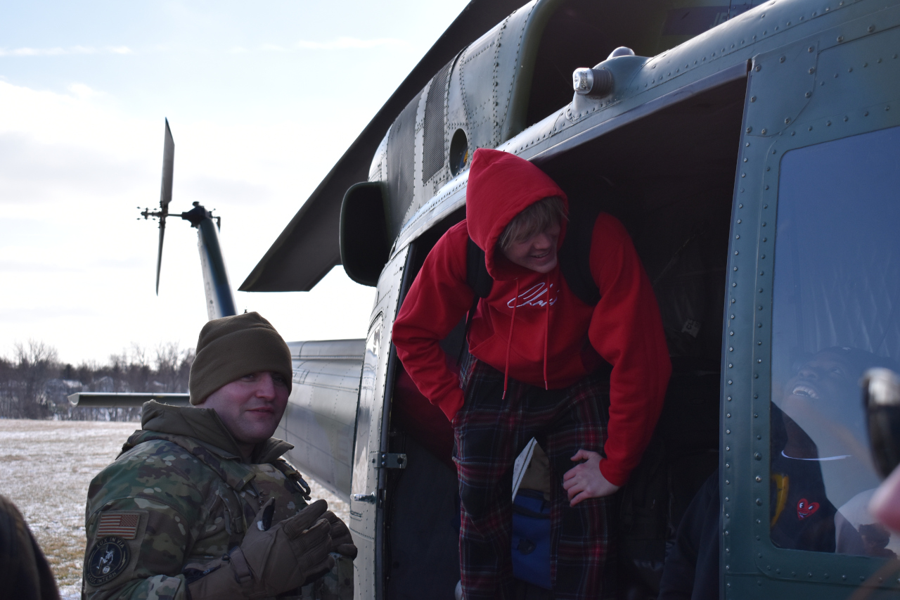 A West High student climbs out of the fuselage while a crew member looks on.