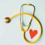 Yellow stethoscope with a red heart under it