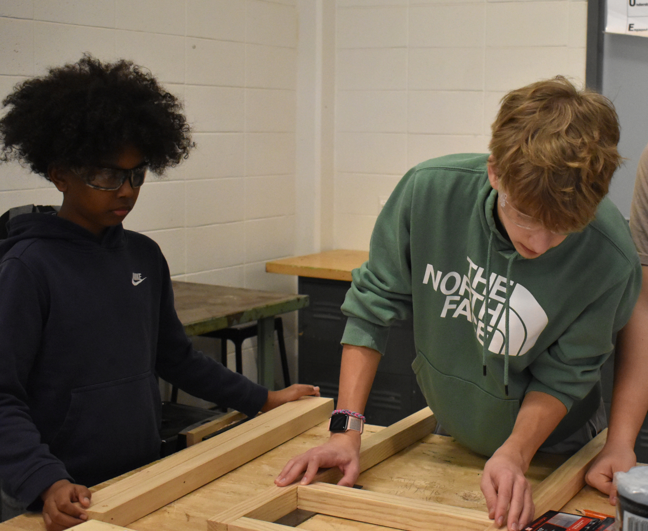 Amjad Ibrahim (left) and Elijah Howe (right), eighth grade Industrial Tech students, fit together pieces of the desk on Friday.