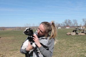 Katie Valentine, Iowa Farm Sanctuary's assistant director of operations, snuggles with one of the Sanctuary's many animals. 