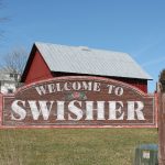 A sign marking Swisher city limits on 120th Street NW greets visitors.