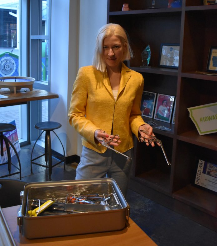 Maria Iliakova poses with some surgical tools that were housed in a metal container. Dr. Iliakova says she has found a more efficient way to keep track of the container and its tools.