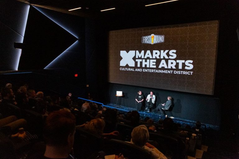 John Schickendanz, Executive Director of The Englert Theatre, and Tammie Walker, Director of the University of Iowa School of Music, address the crowd at a special First Round celebration hosted at FilmScene at The Chauncey on March 27.