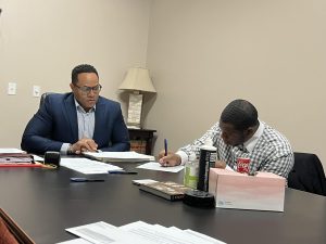Dream City founder and CEO Frederick Newell (right), signs the paperwork purchasing 611 Southgate Ave. in full, while Melvin Shaw (left) of The Law Office of Melvin O. Shaw looks on. 