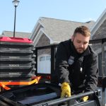 Wesley Smith, owner of Smith Sanitation, takes a moment to adjust a waste bin before setting it on the curb.