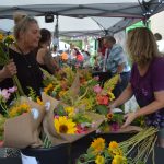Customers select flowers during last summer's Market After Dark. Part of the Downtown Farmers Market, it will remain at its typical location in downtown Cedar Rapids. CREDIT CINDY HADISH