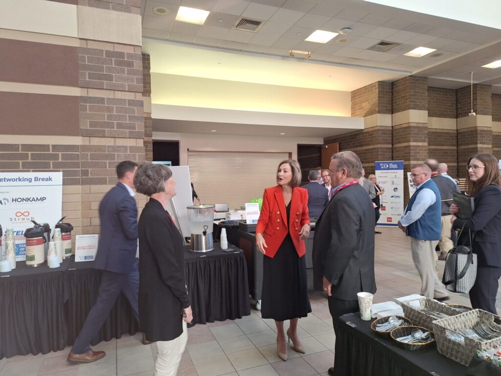 Iowa Gov. Kim Reynolds, center, greets members of the Iowa Association of Business & Industry in the Davenport RiverCenter Great Hall before speaking at ABI’s 2024 Taking Care of Business Conference. CREDIT KENDA BURROWS